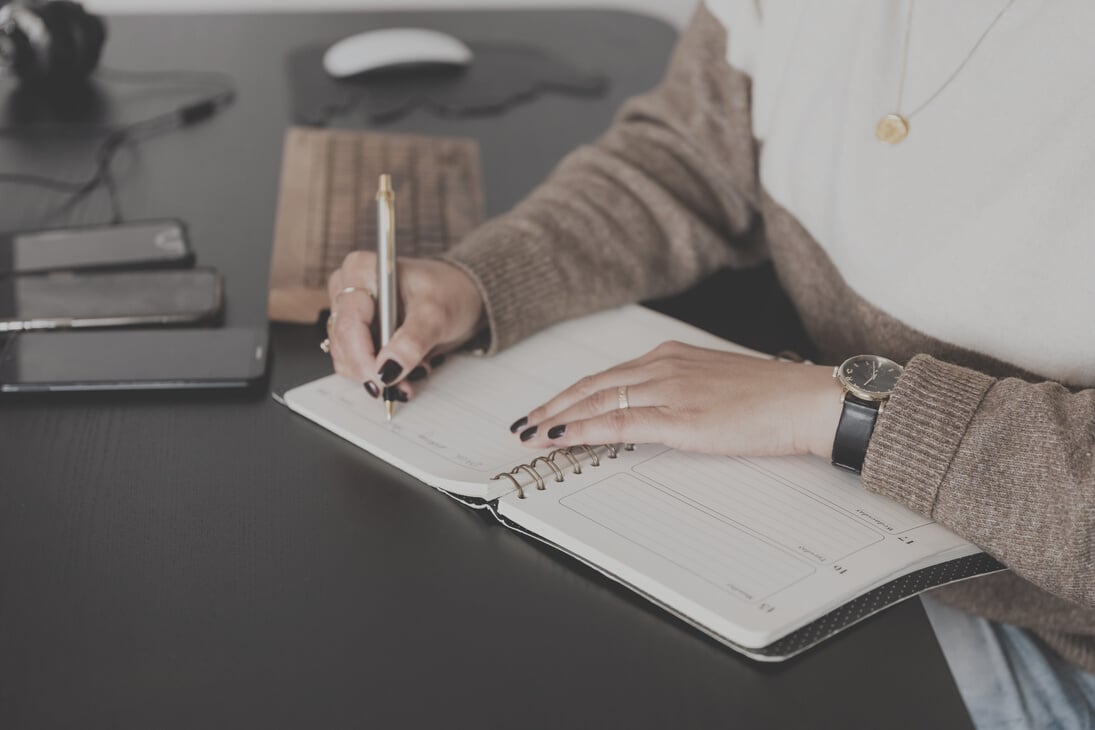 Crop stylish woman taking notes in notebook